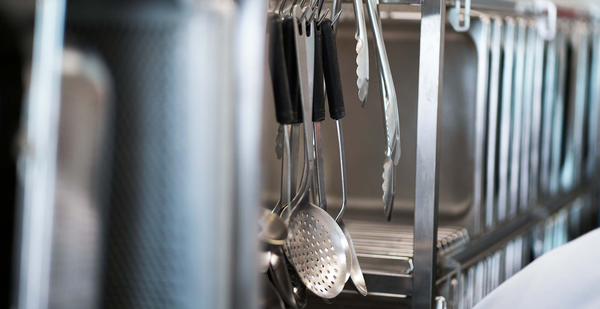 Utensils hanging from a rack. Utensil washers